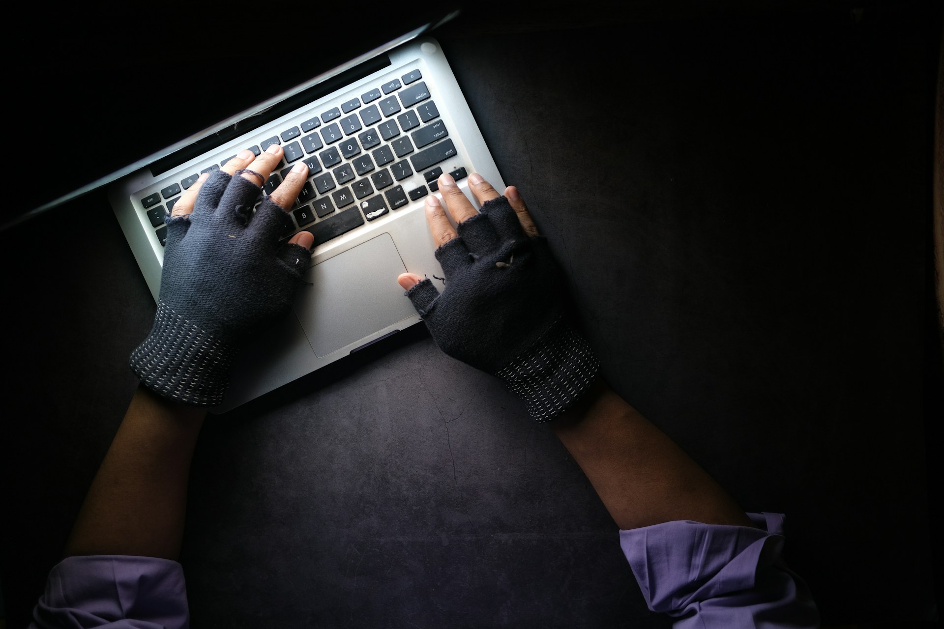 a picture of a hacker typing on a laptop